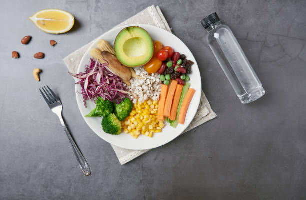 istock Fresh healthy vegetable salad with carrot, corn, tomato, avocado in plate on table background with free text space for diet menu. 1155625480