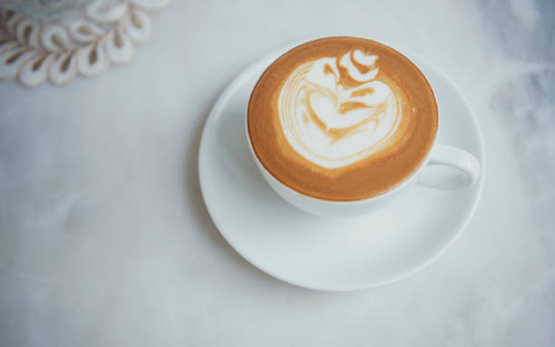 istock latte or Cappuccino with frothy foam, coffee cup top view on table in cafe. 1155625801