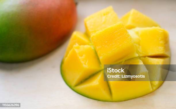 Ripe Juicy Yellow Exotic Mango Cut Into Cubes On Wooden Background Tropical Delicacy Full Of Vitamins For A Healthy Diet Closeup Selective Focus Stock Photo - Download Image Now