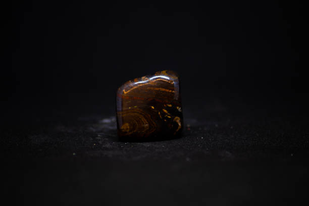 istock tiger´s eye mineral from Australia with black background 1155627927