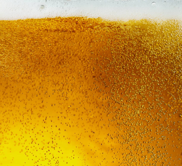 istock Close up view of floating bubbles in light beer texture 1155631648