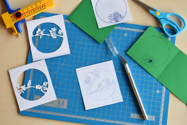 istock Making tunnelbook. 3D greeting card Spring. Artwork equipment and tools for paper cut - cutting knife, sharp box cutter, blue cutting plate, origami paper. Modern 3d origami paper art style. 1155633567