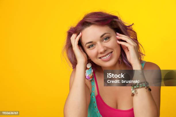 Studio Portrait Of A 30 Year Old Woman With Purple Hair On A Yellow Background Stock Photo - Download Image Now