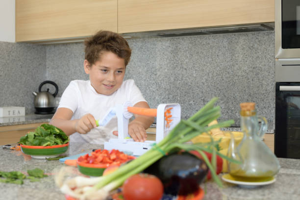 istock Child preparing lunch. Cutting carrots 1155637078