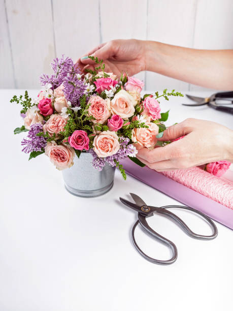 istock Florist at work. Elegant florist hands make bouquet on white background 1155637997