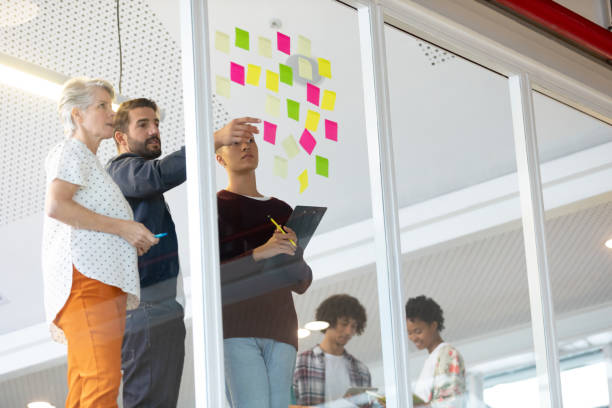 istock Business people discussing over sticky notes in the office 1155638261