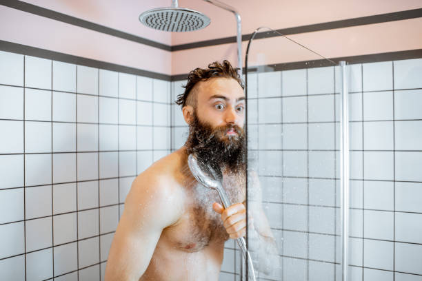 冷たい水でシャワーを takign 男 - men naked shower bathroom ストックフォトと画像