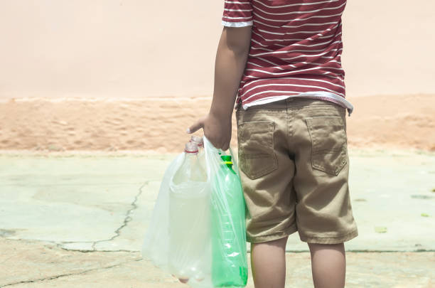 istock Little boy carry garbage bag with plastic bottles 1155640843