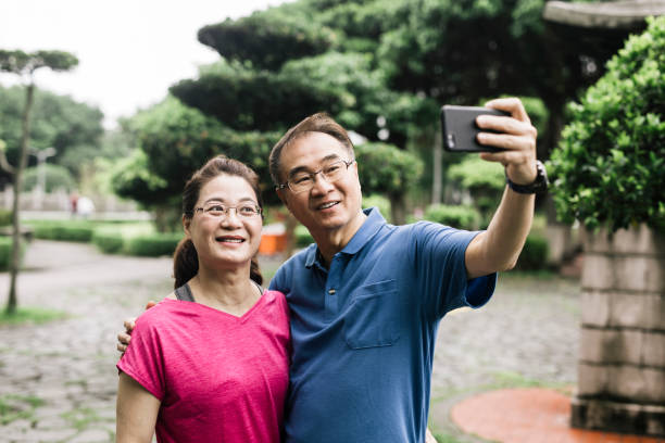 istock Senior couple taking selfie on smart phone at park 1155641395