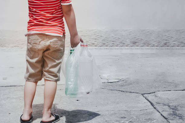 istock Little boy carry garbage bag with plastic bottles 1155642849