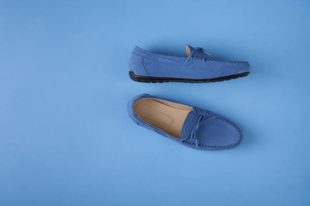 istock Blue suede man's moccasin shoes over blue background 1155645057