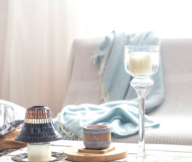 istock Beautiful burning candles with bottles on white table 1155652174