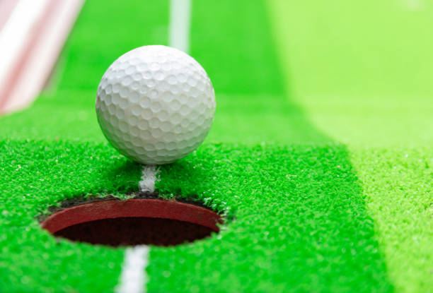 istock golf ball on lip of cup, goal concept 1155652214