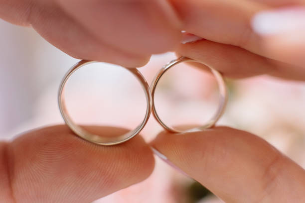 istock Bride and groom hold in their fingers wedding rings 1155659221