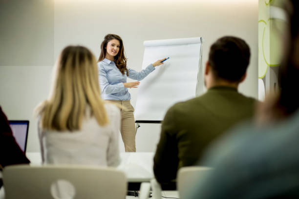 istock Creative positive female leader talking about business plan with students during workshop 1155660966