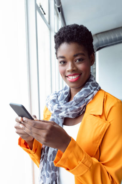 istock Businesswoman using mobile phone near window in office 1155662766