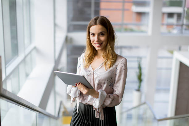 istock Attractive businesswoman using a digital tablet while standing on the stairs in the office 1155664222