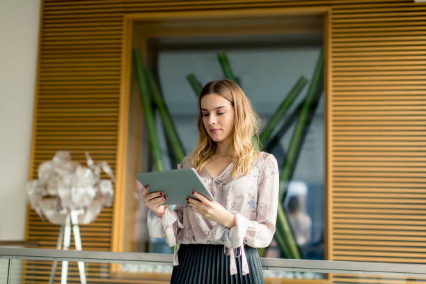 istock Attractive businesswoman using a digital tablet while standing in the office 1155664235