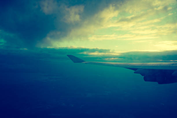 Wing of an airplane flying in the clouds. View from the porthole.