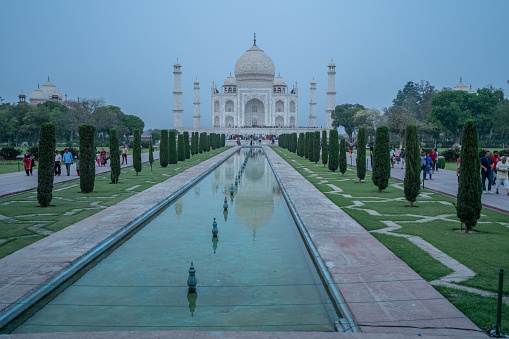 Beautiful view of the Taj Mahal, India one of the 7 wonder of the world, view from the gardens with perfect reflection on water surface