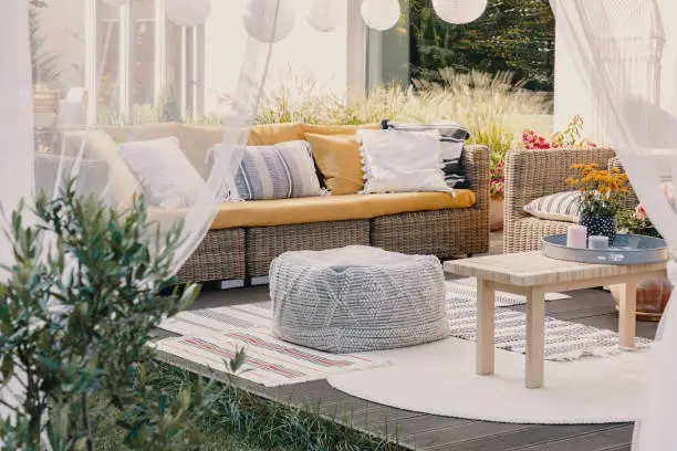 Photo of Terrace design idea with rattan garden furniture set and cozy pillows and rug, real photo