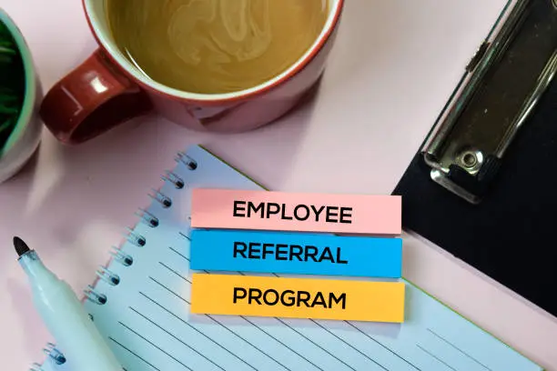 Photo of Employee Referral Program text on sticky notes with office desk concept