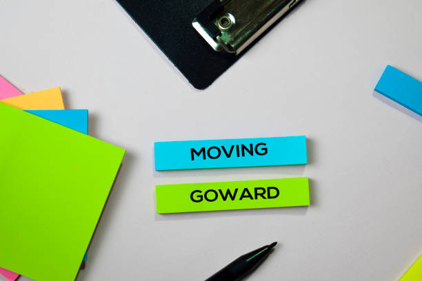 istock Moving Goward text on sticky notes with office desk concept 1155670551