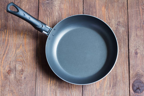 empty frying pan with non-stick coating on wooden background - pan frying pan fried saucepan imagens e fotografias de stock