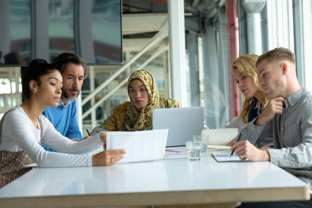istock Business people discussing over document at table in a modern office 1155673034