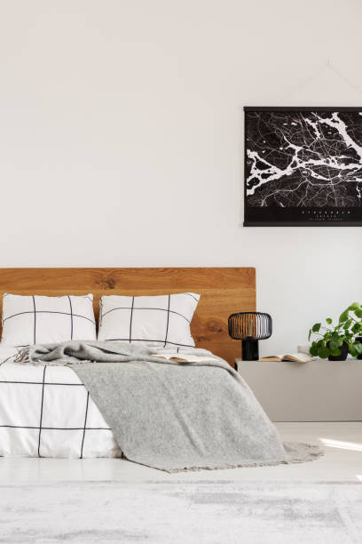 istock Copy space on white wall with black map in modern bedroom with king size bed with wooden headboard 1155675314