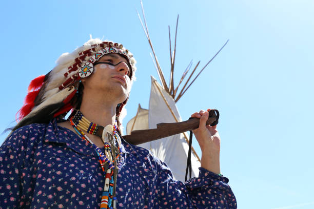 北米インディアンはウィグワムの近くに武器を持って立っている - wigwam tent north american tribal culture indigenous culture ストックフォトと画像