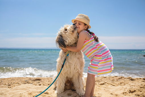 Adorable young girl enjoying family vacation on a summer day at the beach.