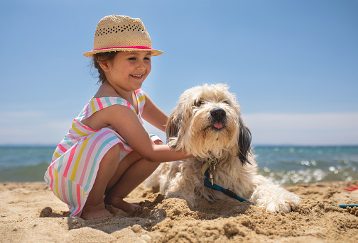 Adorable young girl enjoying family vacation on a summer day at the beach.