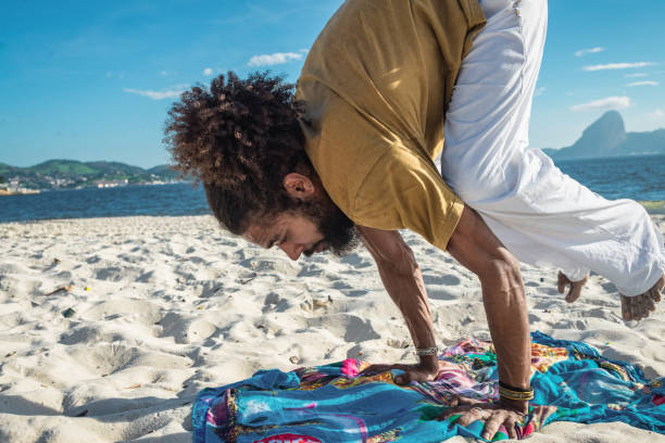 istock man doing yoga on the beach 1155679283