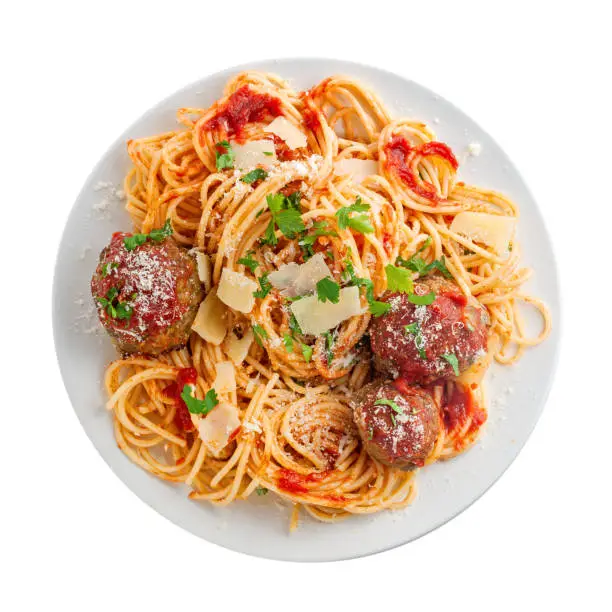 Spaghetti with meatballs, parmesan and tomato sauce on a plate. Tasty Italian pasta food. Top view shot above isolated on white background.