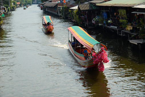 Long tail boats are sailing in canal. Ship transport is a Thai transport since the past. Until now, there are still many general passengers who do not disappear from Thai society.
