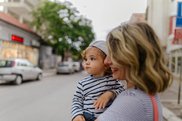 mamá e hijo en un paseo por la ciudad - familia de cruzar la calle fotografías e imágenes de stock
