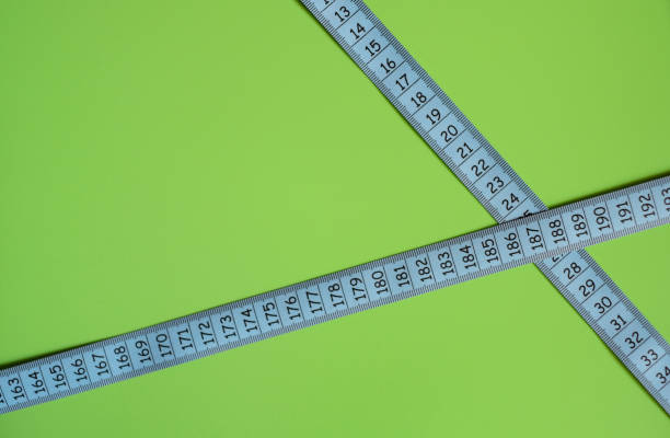 Blue measuring tape on green background with black numbers. stock photo
