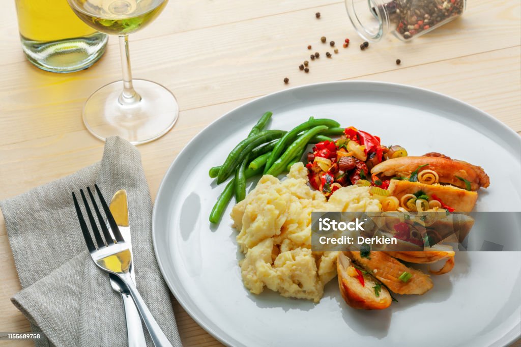 Chicken fillet with mashed potato Roasted chicken breast fillet with mashed potato, green beans and vegetable sauce with white wine on a table. Traditional healthy food. Above Stock Photo