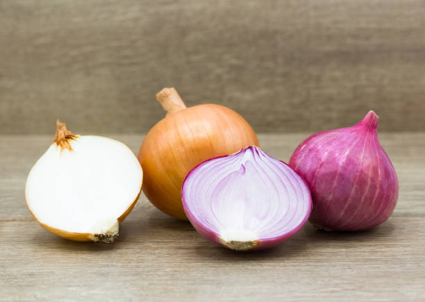istock Red sliced onion on a wooden background 1155690253