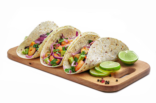 Tacos with shrimps., avocado and red onion on a wooden table. Traditional American fast food. Studio shot, isolated on white background.