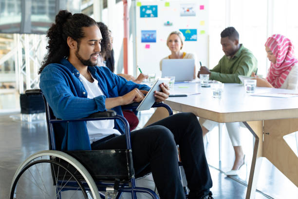istock Disabled businessman using digital tablet in conference room during meeting 1155692485