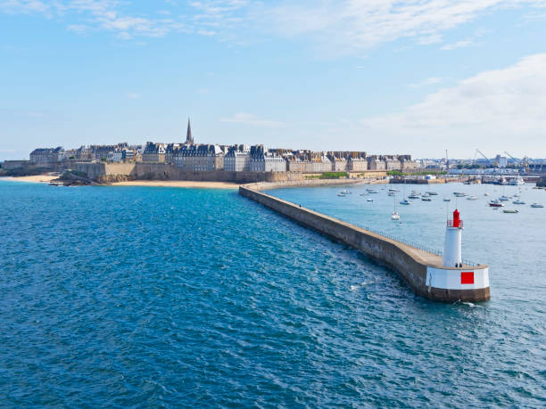 Leaving St Malo in the morning sunshine Passing the curved breakwater of Saint Malo, with the city and its walls in the background as we leave port in the morning sunshine groyne photos stock pictures, royalty-free photos & images