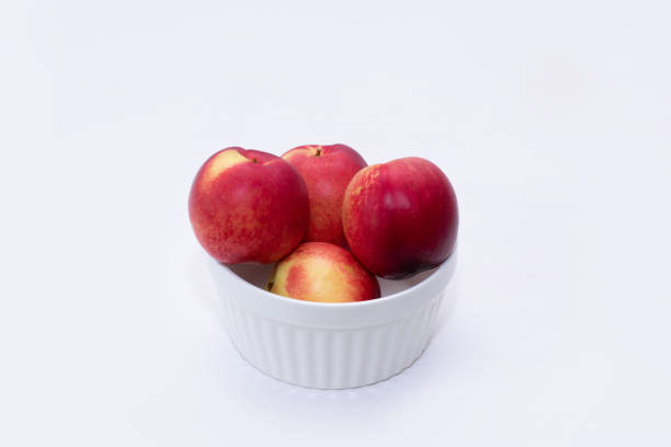 istock Group of whole nectarine fruits isolated on white background 1155696079