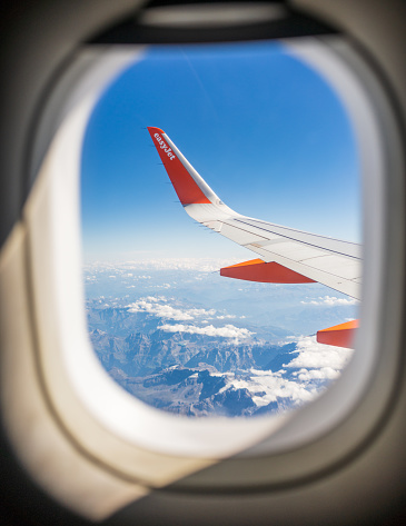 Italy - The Easyjet logo and bright orange colouring on the wing of a passenger jet on a short haul flight from the UK to Italy.