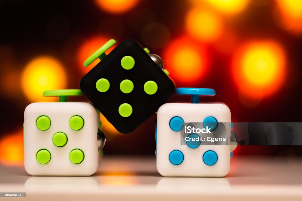 Fidget Cube Anti Stress Toy Detail Of Finger Play Toy Used For Relax Gadget  Placed On Colorful Bokeh Background Stock Photo - Download Image Now -  iStock