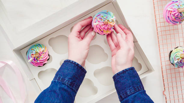 istock Boxing unicorn chocolate cupcakes into a white cupcake box. 1155698666