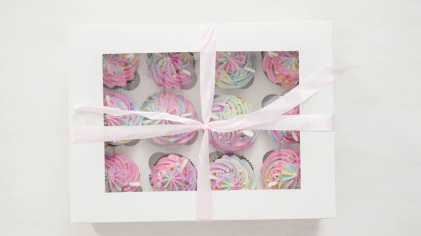 istock Boxing unicorn chocolate cupcakes into a white cupcake box. 1155699089