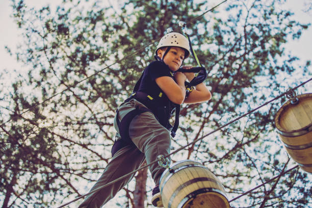 parcours d’obstacles dans un parc d’aventures - high up obstacle course ropes course teenage boys photos et images de collection