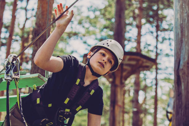 parcours d’obstacles dans un parc d’aventures - high up obstacle course ropes course teenage boys photos et images de collection